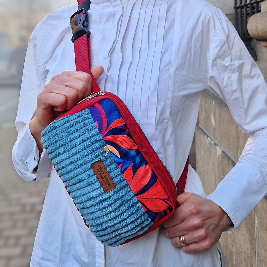 Ręcznie szyta nerka damska z czerwonym paskiem, wykonana z niebieskiego sztruksu tapicerskiego i materiału z czerwono-granatowym motywem liści