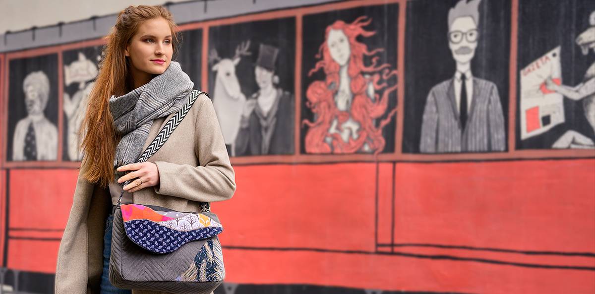 Torba listonoszka duża handmade szyta z tkanin recyclingowych z patchworkowym  motywem  pejzażu na klapie, z zastosowaniem upyclingu w kolorze grafitowym z czerwonymi i pomarańczowymi akcentami